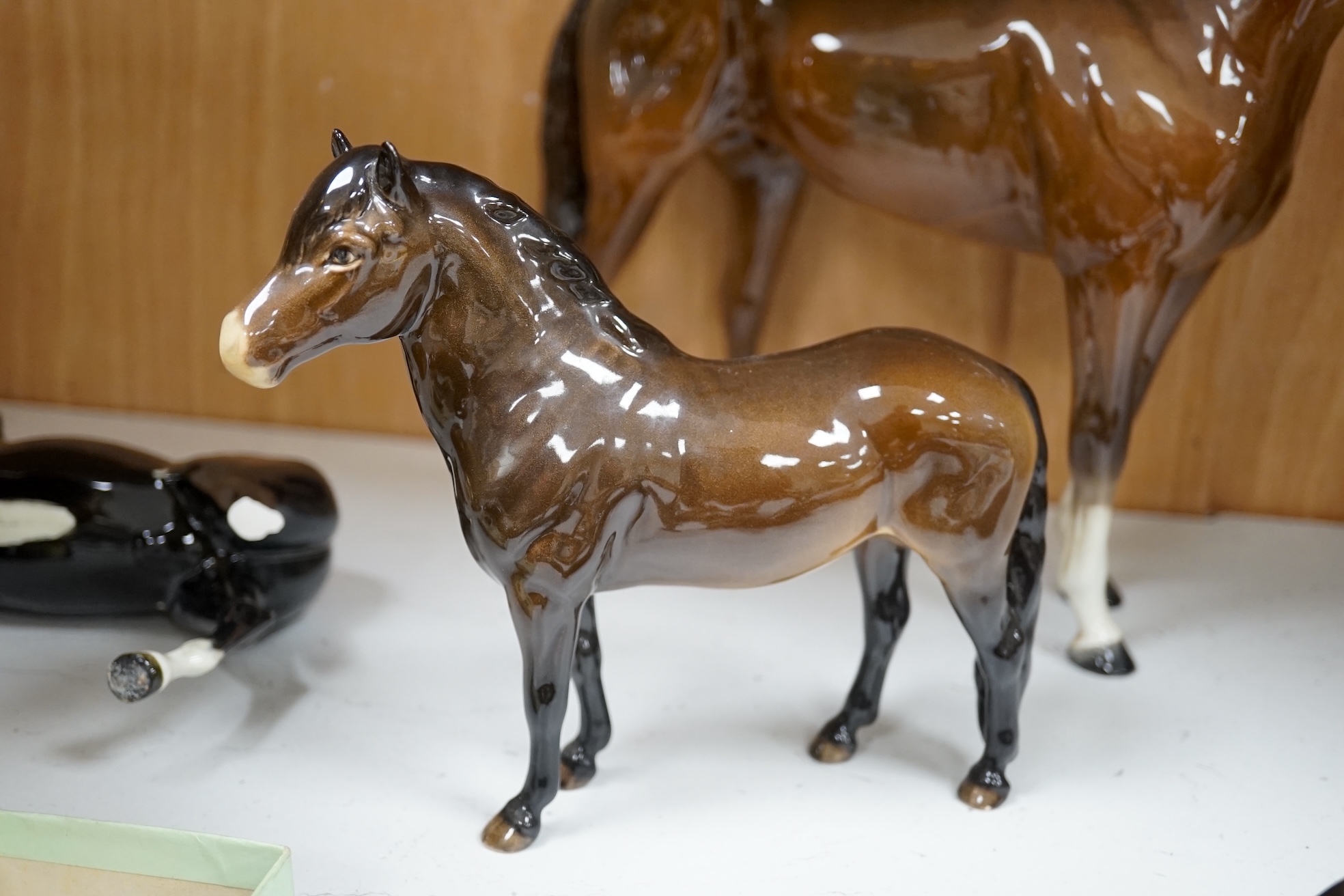 A large Beswick Chestnut horse, together with three other smaller horses and an Exmoor pony, tallest 30cm high (5). Condition - Exmoor pony good, all the others have broken legs or ears